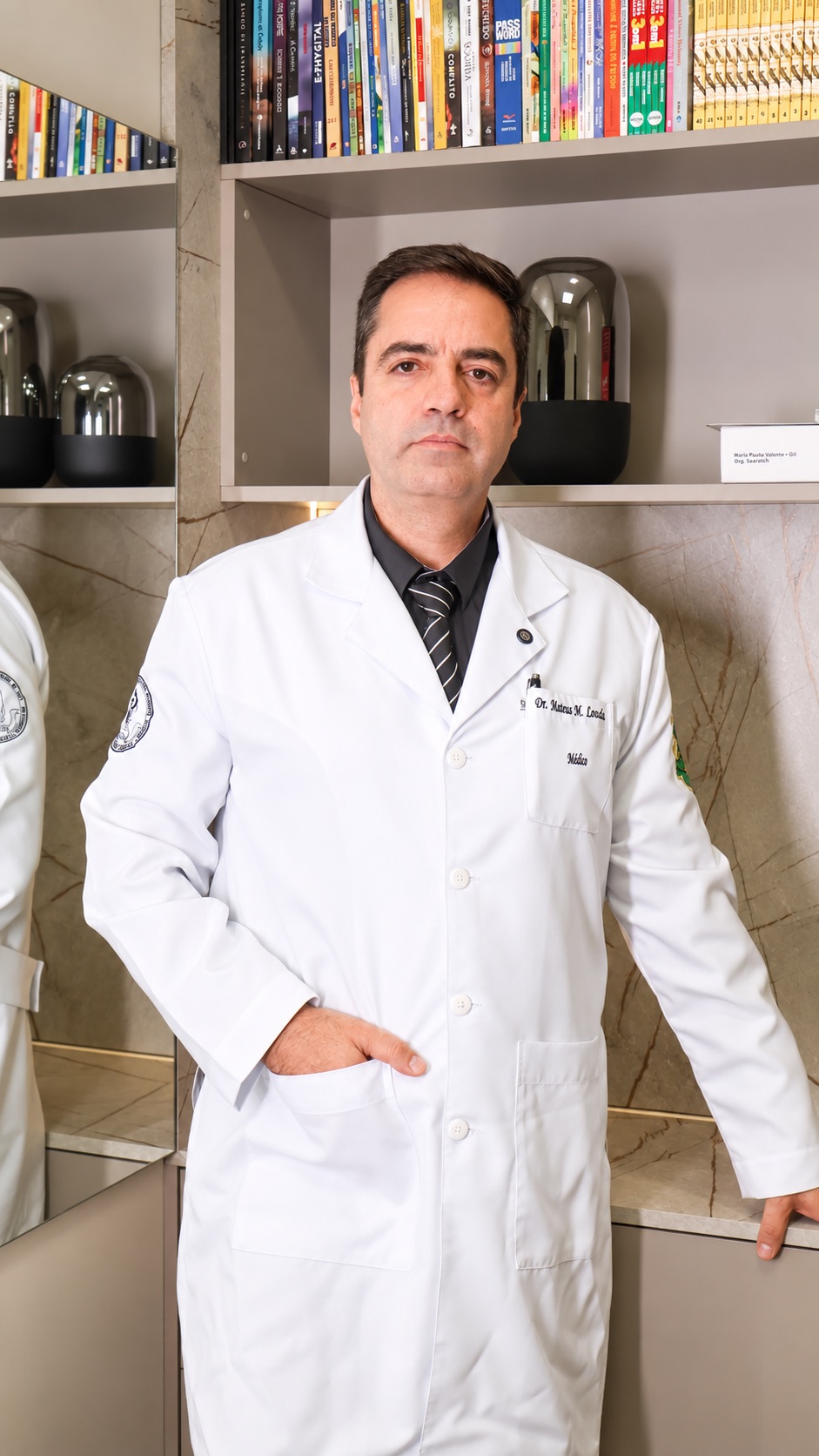 Dr. Mateus Louzada em pé no consultório