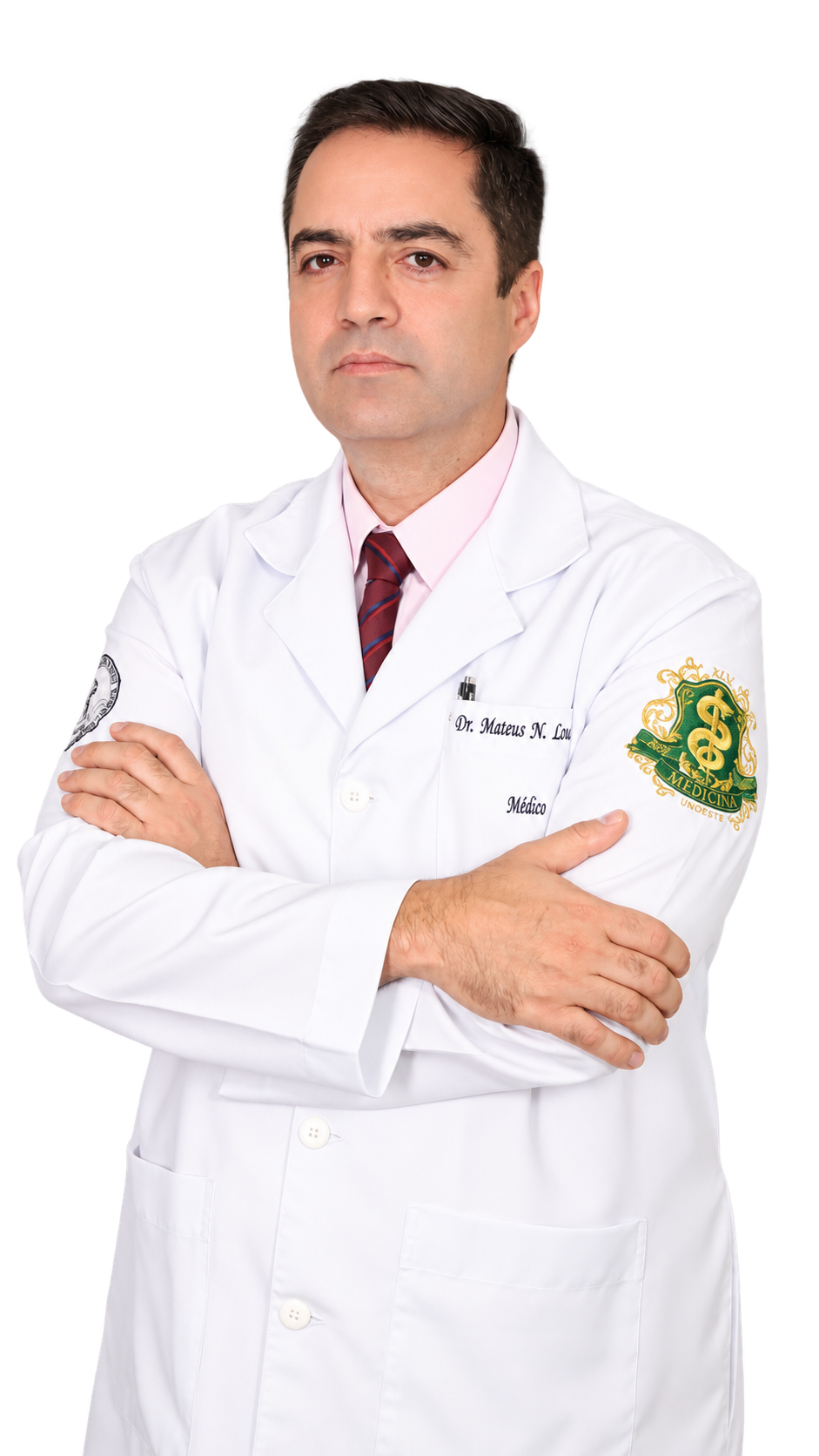 Dr. Mateus Louzada de jaleco, com os braços cruzados